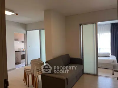 Modern apartment interior with cozy living room and bedroom, featuring sleek furniture and natural light.