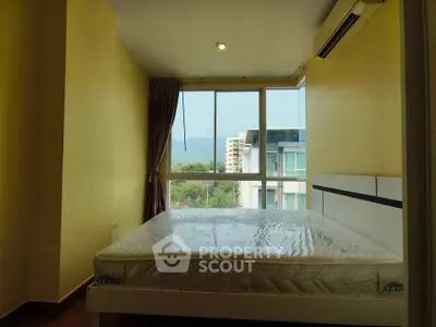 Spacious bedroom with large window offering scenic view of mountains and cityscape.