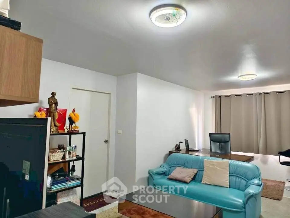 Modern living room with blue sofa and office desk, perfect for work-from-home setup.