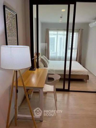 Modern bedroom with study area featuring a sleek desk and stylish decor.