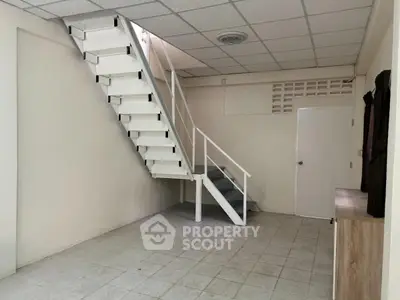 Spacious interior with modern staircase and tiled flooring
