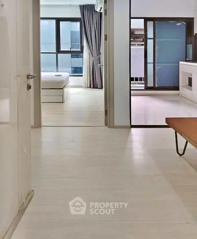 Modern apartment interior with light wood flooring and large windows