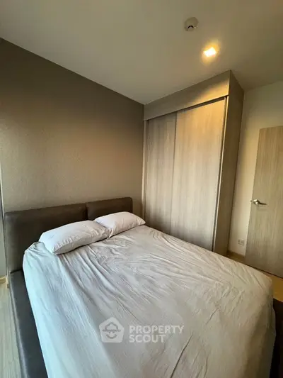 Modern bedroom with sleek design and ample natural light, featuring a comfortable bed and stylish wardrobe.