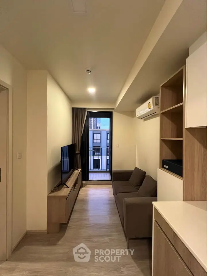 Modern living room with sleek furniture and balcony view in stylish apartment.