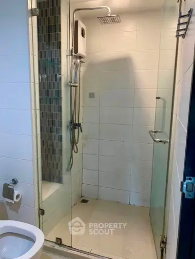 Modern bathroom with glass shower enclosure and sleek fixtures in a contemporary home.