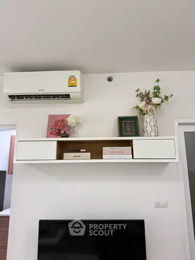 Modern living room with wall-mounted air conditioner and decorative shelving.