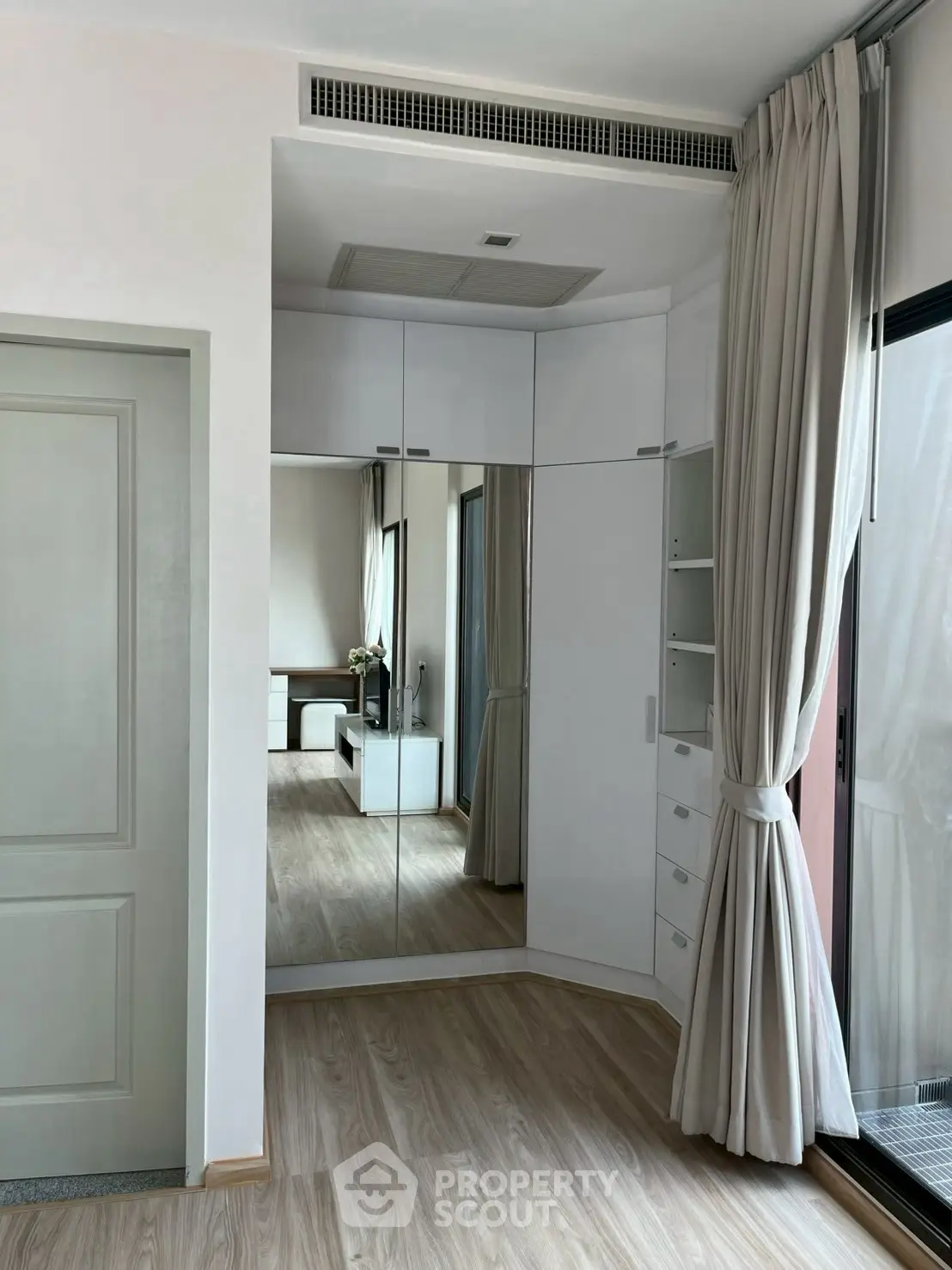 Modern bedroom with mirrored wardrobe and elegant curtains
