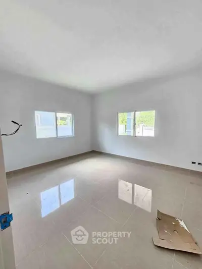 Spacious unfurnished room with large windows and tiled floor, ready for customization.