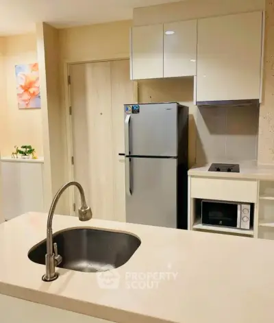 Modern kitchen with sleek appliances and stylish cabinetry in a contemporary apartment.