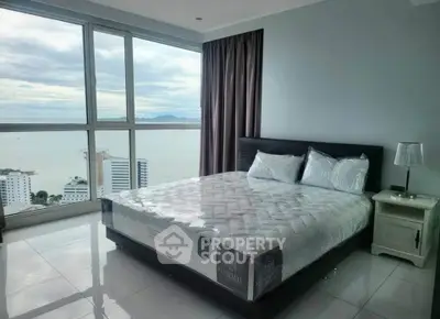 Luxurious bedroom with stunning ocean view and modern furnishings in high-rise apartment.