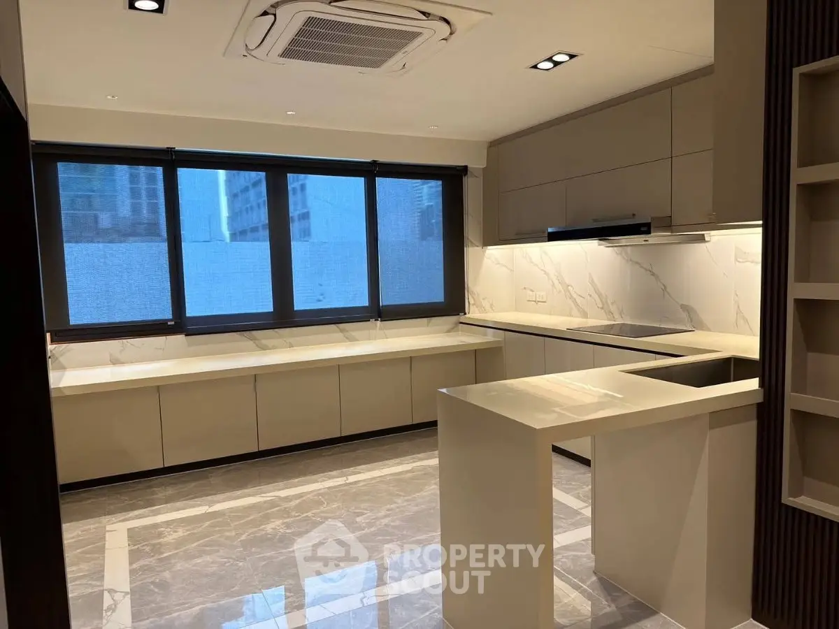 Modern kitchen with sleek cabinetry and marble countertops in a luxury apartment.