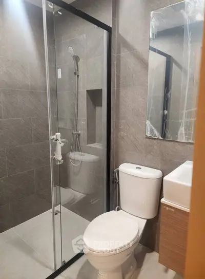 Modern bathroom with glass shower and sleek fixtures in contemporary design.