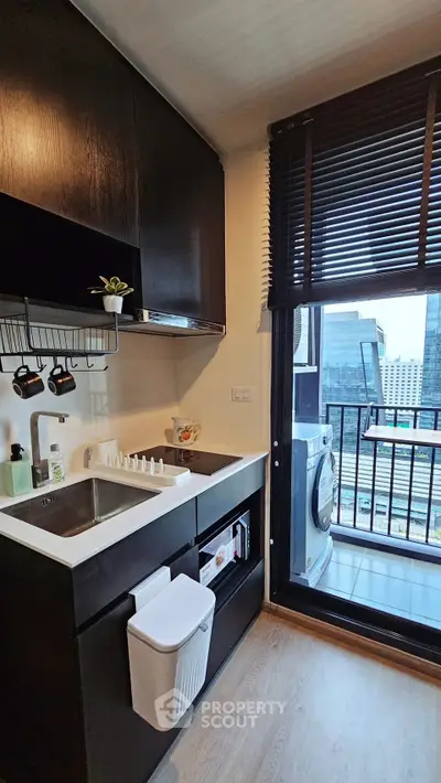 Modern kitchen with sleek cabinets and balcony view in urban apartment