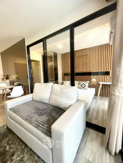 Modern living room with cozy sofa and stylish decor in open-plan apartment.