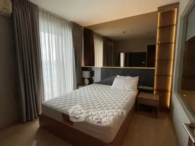 Modern bedroom with stylish lighting and large window for natural light.