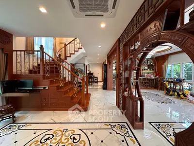 Luxurious open-plan living area with elegant wooden staircase and intricate floor design