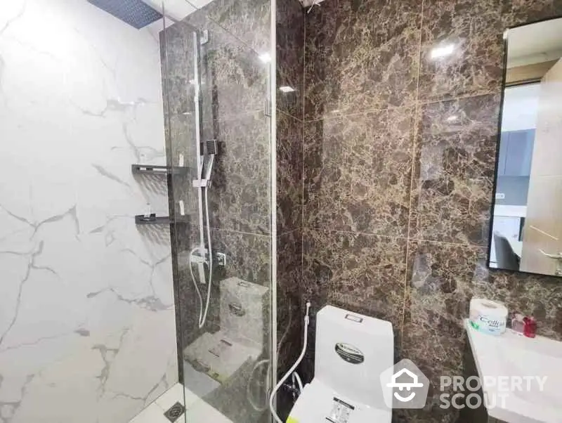 Modern bathroom with marble tiles and glass shower enclosure