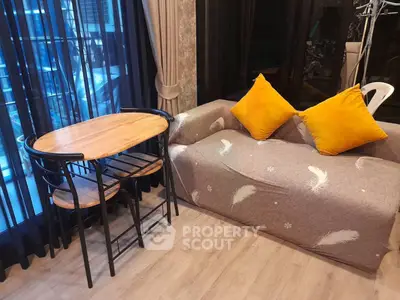 Cozy living room with stylish sofa and dining table, perfect for modern urban living.