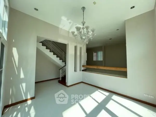 Spacious modern living room with elegant chandelier and natural light