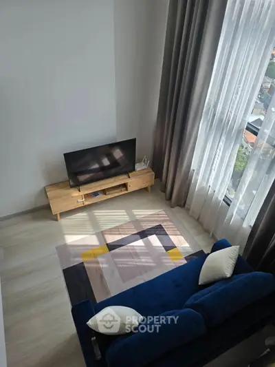 Modern living room with stylish blue sofa and large window view