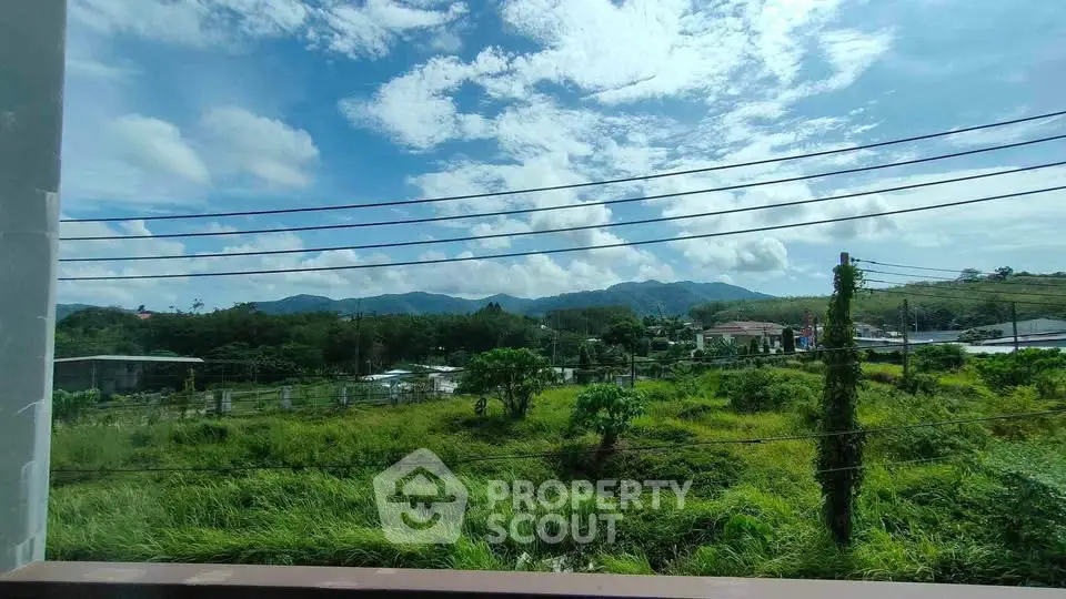 Stunning panoramic view of lush greenery and mountains from a property window.
