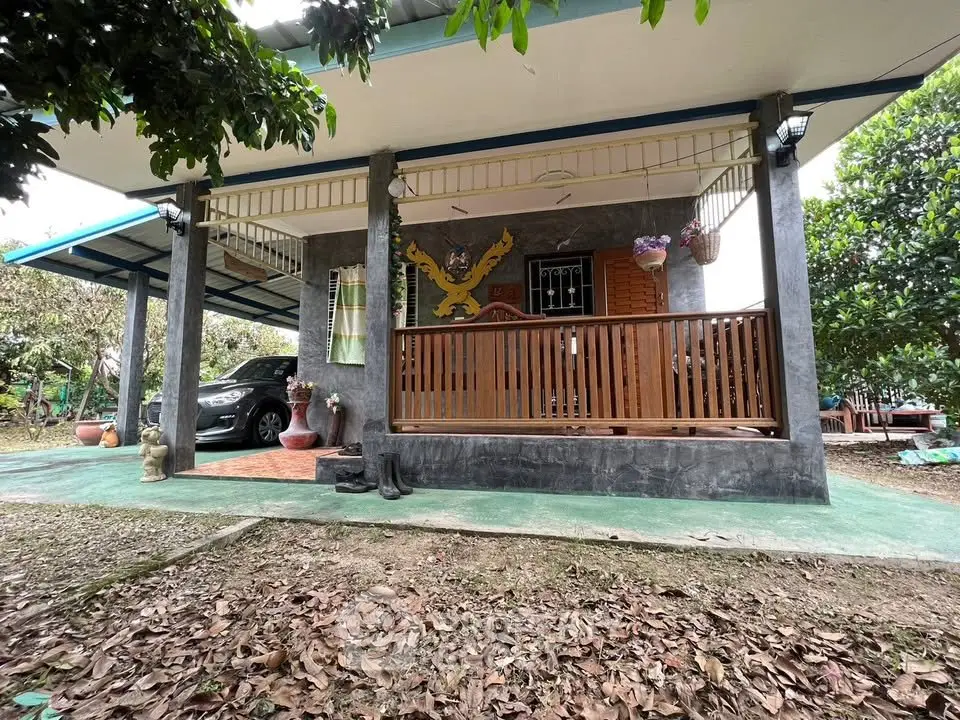 Charming rural home with covered porch and lush greenery, perfect for serene living.