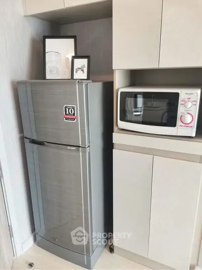 Modern kitchen with sleek fridge and microwave in compact layout