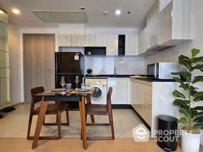 Modern kitchen with dining area, sleek cabinets, and integrated appliances in stylish apartment.