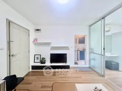 Modern living room with sleek design and open layout, featuring a TV and stylish shelving.