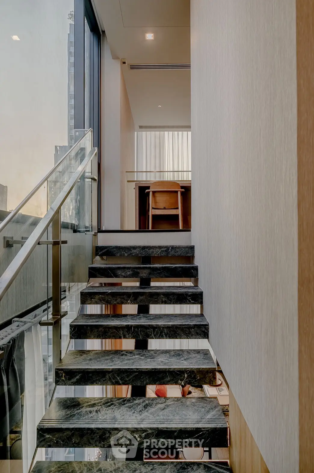 Elegant modern staircase with glass railing in luxury apartment