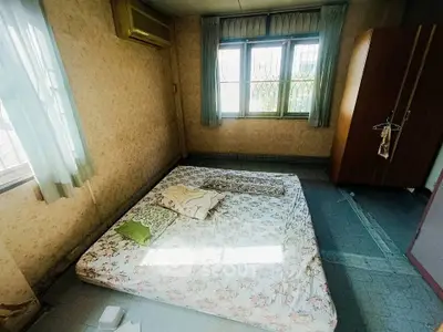Cozy bedroom with large window and air conditioning, featuring a minimalist mattress setup.