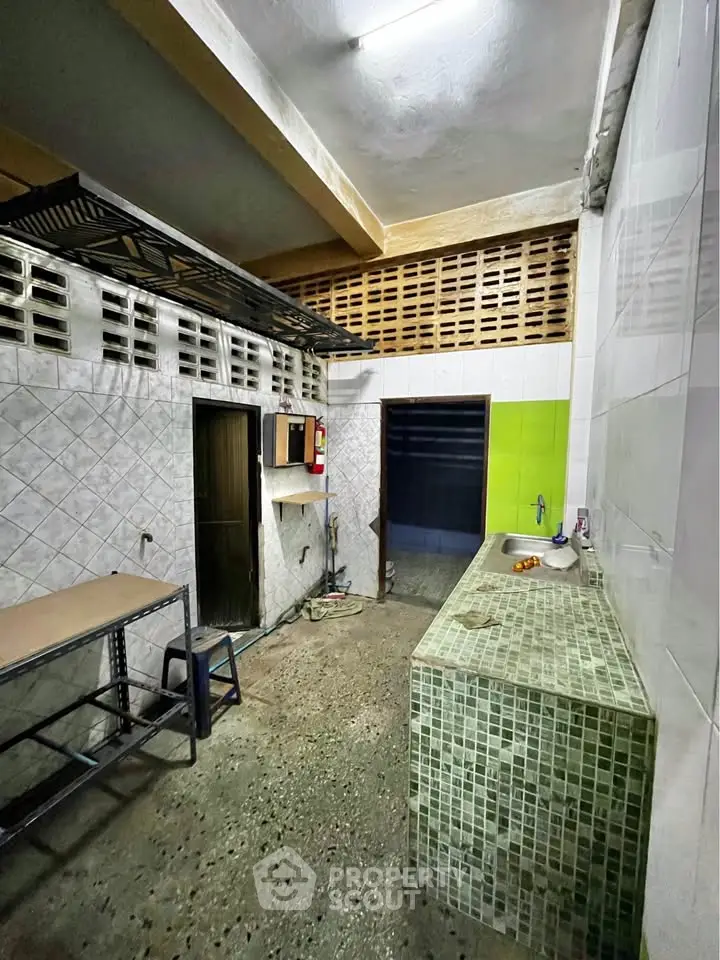 Industrial-style kitchen with tiled counters and open shelving