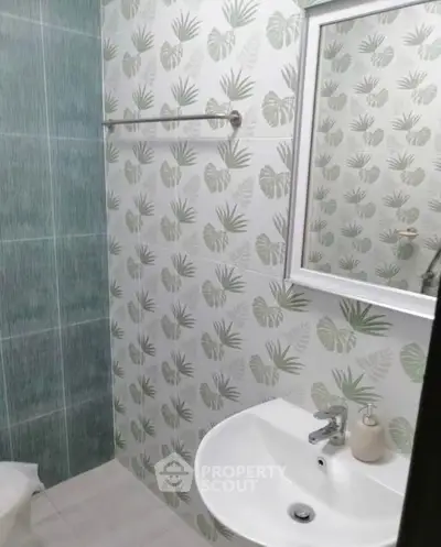 Charming bathroom with tropical leaf wallpaper and modern fixtures