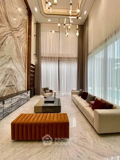 Luxurious modern living room with high ceilings, elegant lighting, and marble flooring.