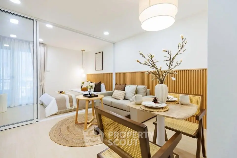 Modern open-plan living room with dining area and cozy bedroom in elegant apartment.