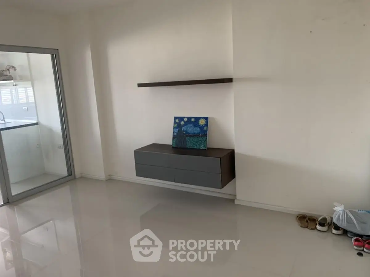 Minimalist living room with wall-mounted shelf and modern decor