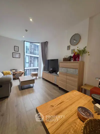 Modern living room with stylish decor and large window offering city view