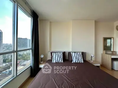 Spacious bedroom with large windows offering stunning city views in modern apartment.