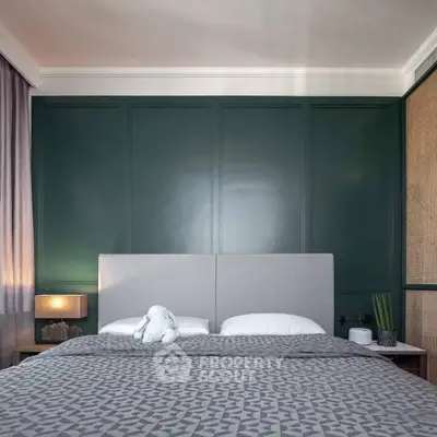 Elegant bedroom with modern decor and plush bedding, featuring a stylish green accent wall.