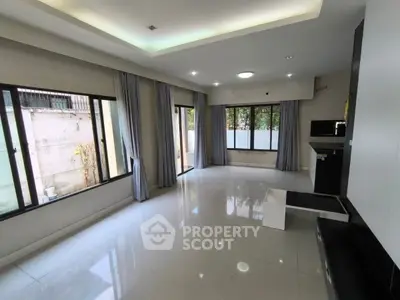 Spacious modern living room with large windows and sleek tile flooring