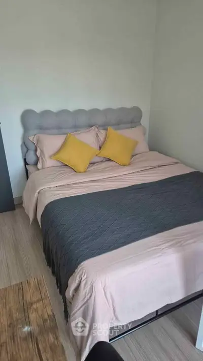 Cozy bedroom with stylish bedding and accent pillows in modern apartment.