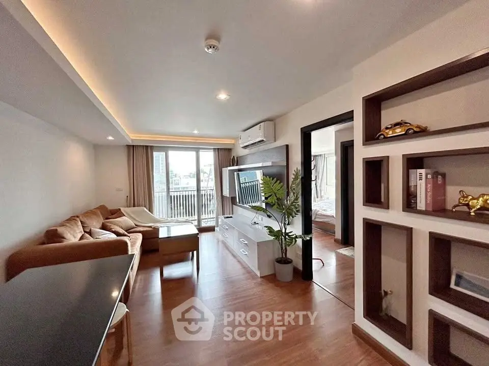 Modern living room with stylish decor and balcony view in a contemporary apartment.