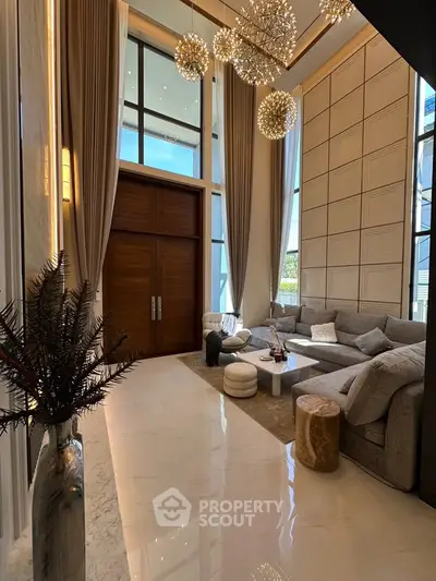 Luxurious high-ceiling living room with elegant decor and large windows