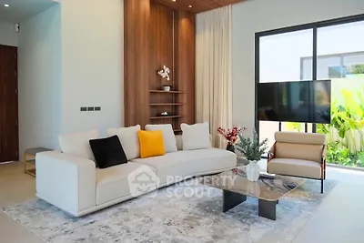 Modern living room with elegant decor, large sofa, and natural light from floor-to-ceiling windows.