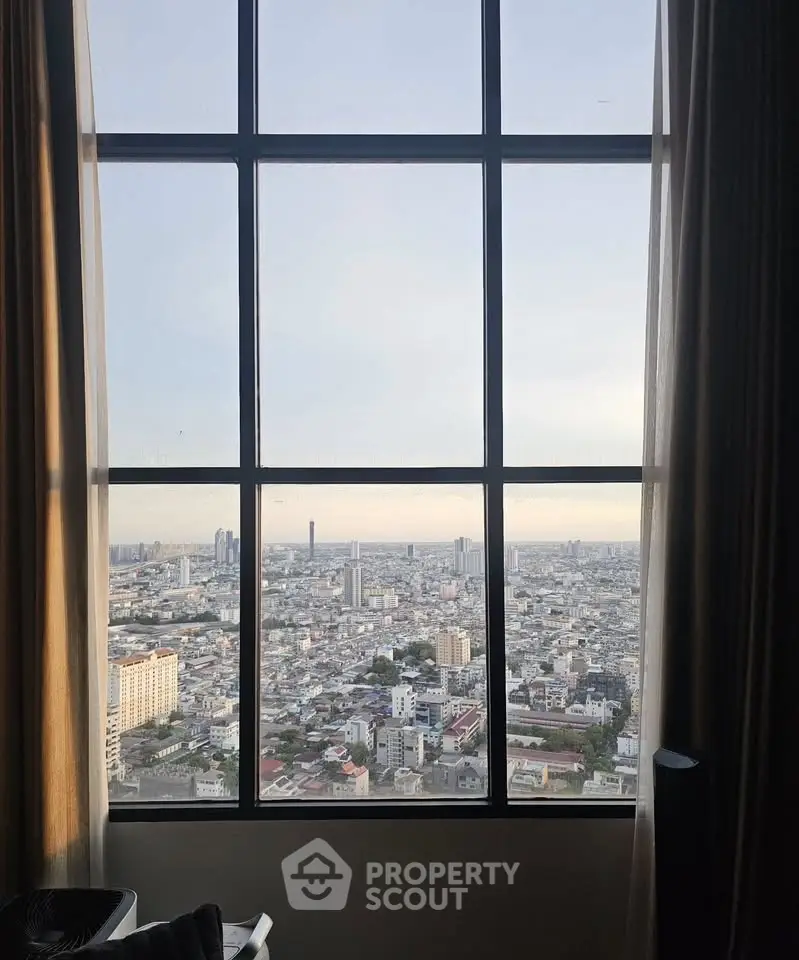 Stunning cityscape view from a high-rise apartment window, showcasing urban living at its finest.
