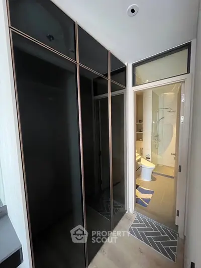 Modern bathroom with sleek black storage and glass shower enclosure