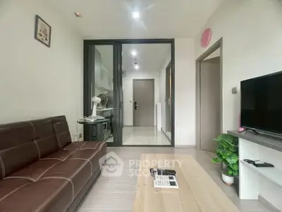 Modern living room with sleek brown sofa and TV, featuring a stylish open layout and contemporary decor.
