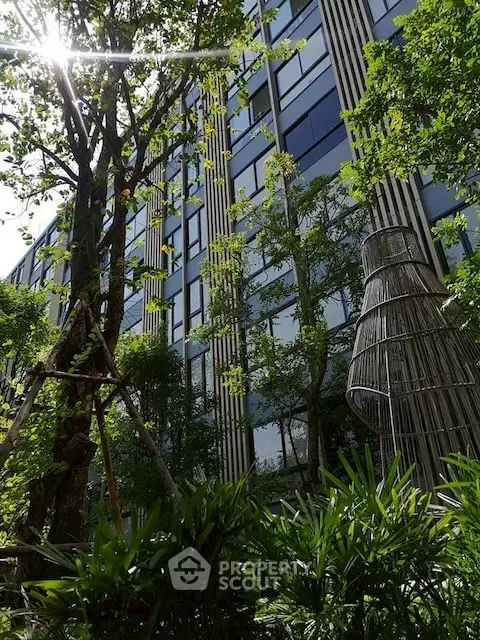 Modern building exterior with lush greenery and unique architectural design.