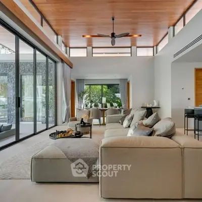 Luxurious modern living room with large windows and elegant decor.