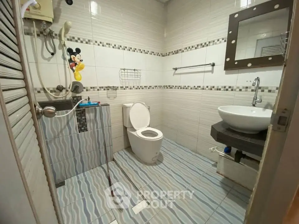 Charming bathroom with modern fixtures and playful decor, perfect for a cozy home.
